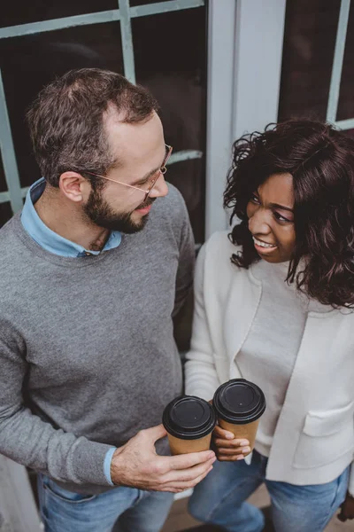 Fröhliche multiethnische Kollegen, die über Arbeit und Kaffee reden — Stockfoto