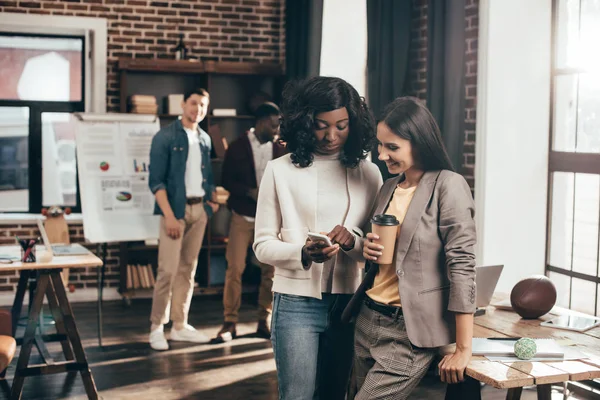 Casual businesspeople using smartphone and working together on project in loft office — Stock Photo