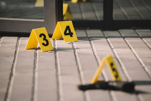 Blured close-up vista da cena do crime com arma e números — Fotografia de Stock