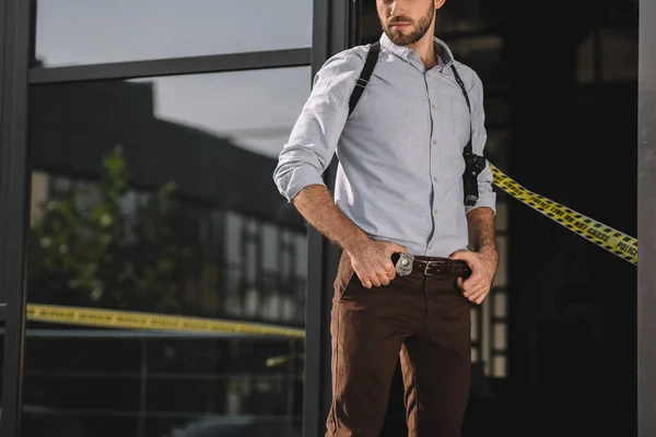 Male detective standing with arms akimbo — Stock Photo