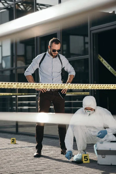 Male detective looking at work of criminilogist — Stock Photo