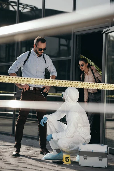 Detectives and criminologist communicating at crime scene — Stock Photo
