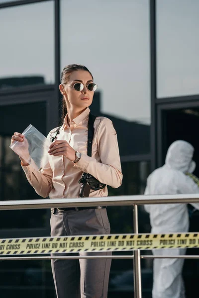 Female detective with evidence package in hands — Stock Photo