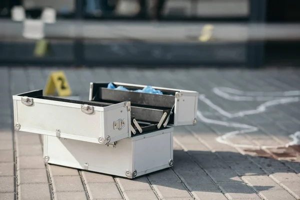 Investigation tool box standing open near chalk line — Stock Photo