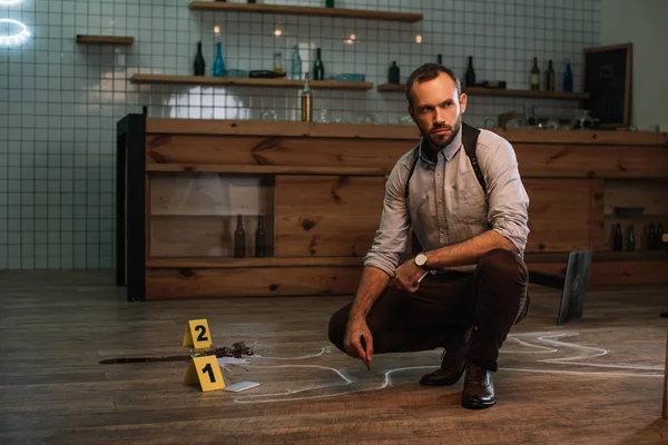 Pensive male detective sitting at crime scene — Stock Photo