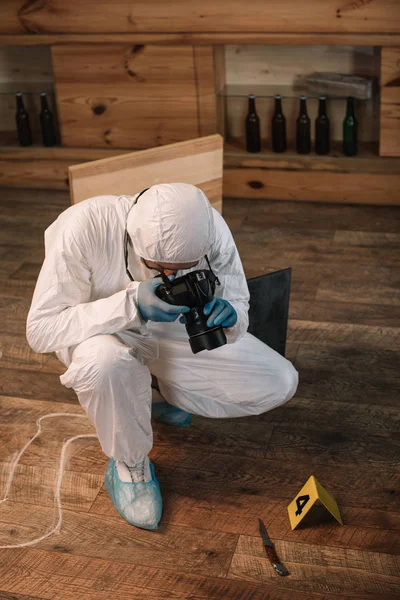 Forensic investigator documenting evidence with camera at crime scene — Stock Photo