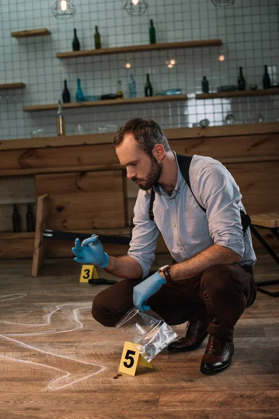 Concentrated male detective collecting evidence at crime scene — Stock Photo