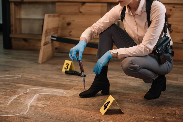 Vista recortada de la detective mujer recogiendo pruebas en la escena del crimen - foto de stock