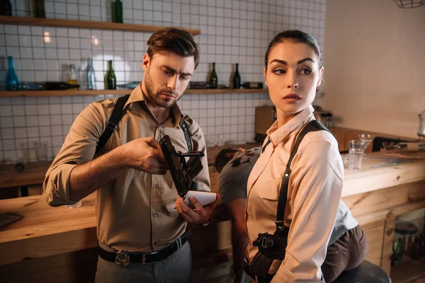 Serious female and male detectives collecting evidence and investigating dead body at crime scene — Stock Photo