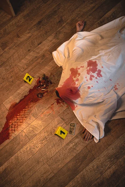 Top view of dead body covered with white sheet at crime scene — Stock Photo