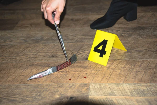 Vista recortada de la mano examinando pruebas en la escena del crimen - foto de stock