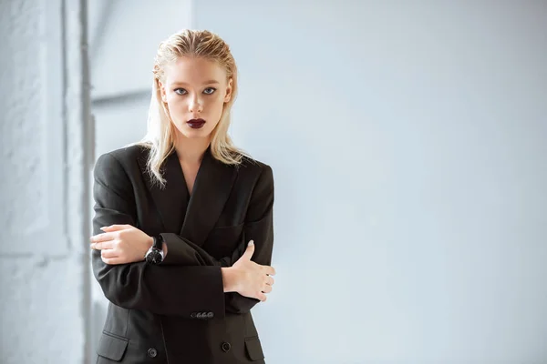 Schöne modische Frau im schwarzen Anzug posiert auf grau — Stockfoto