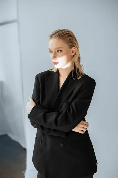 Attraktives Model in formaler Kleidung mit Lichtstrahl im Gesicht posiert für Mode-Shooting — Stockfoto