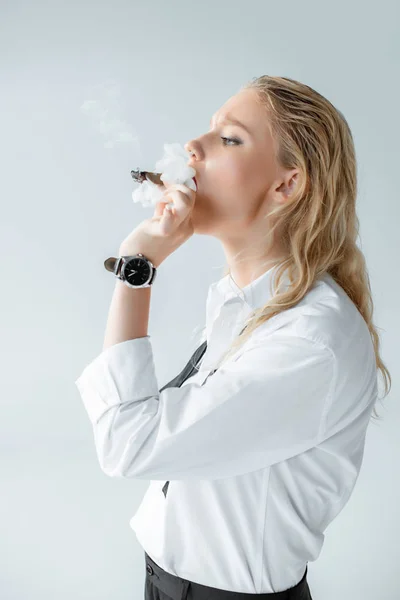 Beautiful fashionable young woman smoking cigar isolated on grey — Stock Photo