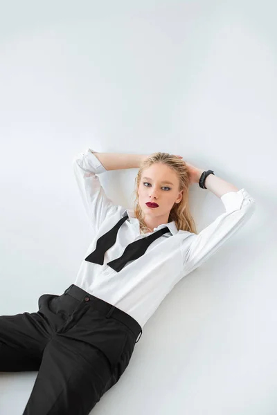 Beautiful fashionable blonde girl posing in formal wear isolated on grey — Stock Photo