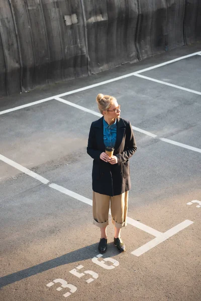 Attrayant fille à la mode avec du café pour aller debout sur le parking — Photo de stock