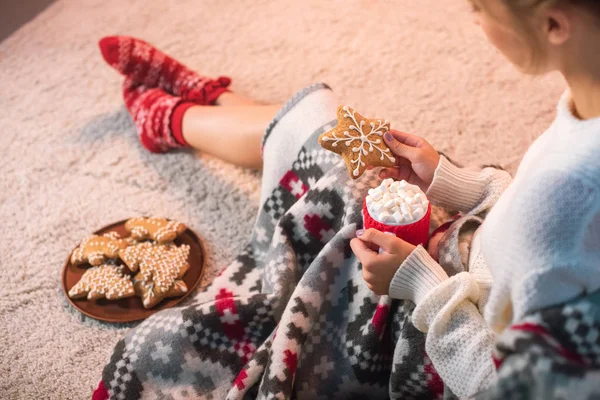 Mujer en blanco celebración de Navidad galleta de jengibre y taza con cacao caliente - foto de stock