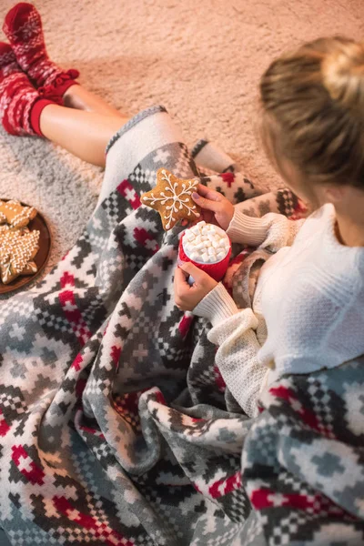 Mujer en blanco celebración de Navidad galleta de jengibre y taza con cacao caliente - foto de stock