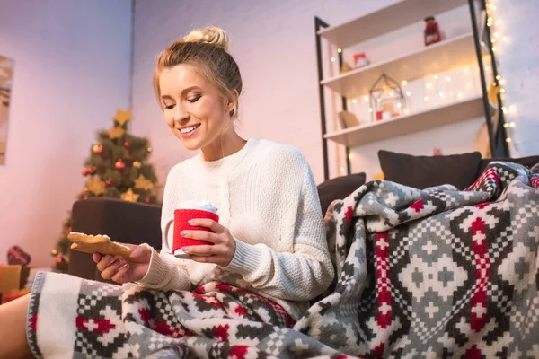 Жінка в порожньому тримає різдвяне імбирне печиво і чашку з гарячим какао — стокове фото
