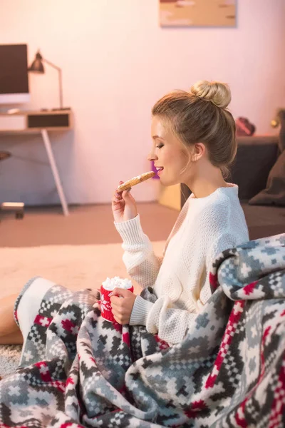 Mujer en blanco celebración de Navidad galleta de jengibre y taza con cacao caliente - foto de stock