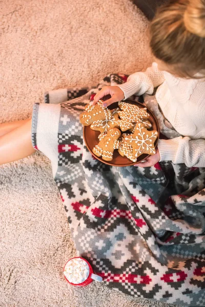 Mujer en estampado en blanco celebración de galletas de jengibre de Navidad - foto de stock
