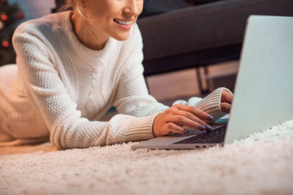 Cropped view of woman lying on floor using laptop — Stock Photo