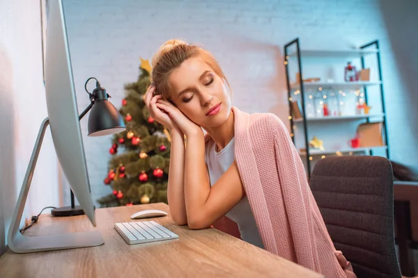 Sognante giovane donna bionda con gli occhi chiusi seduta alla scrivania del computer a casa — Foto stock