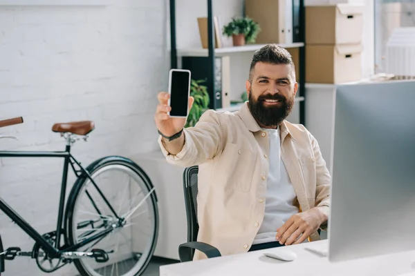 Uomo d'affari sorridente che mostra smartphone alla fotocamera — Foto stock