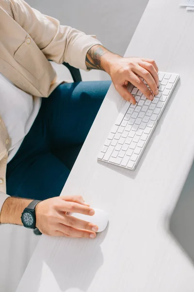 Vue recadrée des mains masculines avec clavier et souris d'ordinateur — Photo de stock