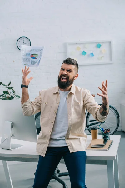 Aggressive boss throwing papers in air in modern office — Stock Photo