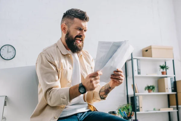 Aggressive boss screaming and looking at papers in modern office — Stock Photo