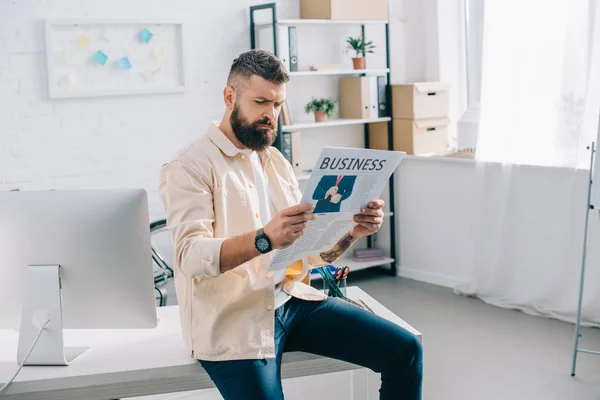 Casual empresário sentado e lendo jornal no escritório moderno — Fotografia de Stock