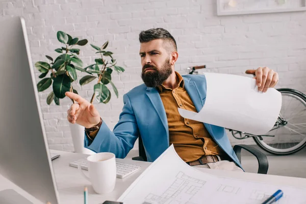 Architecte regardant moniteur et gestuelle dans le bureau moderne — Photo de stock