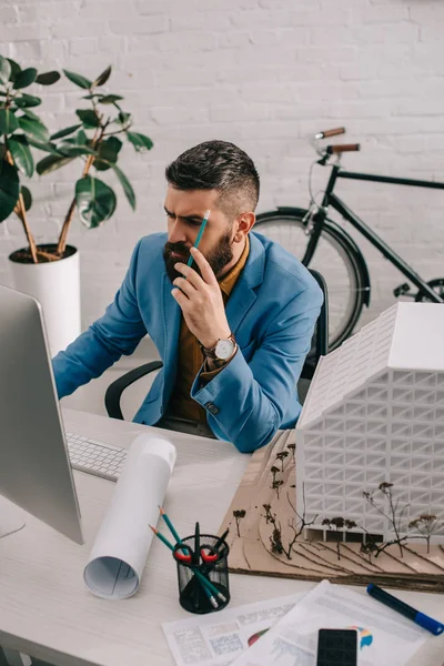 Beschäftigter erwachsener männlicher Architekt in formaler Kleidung arbeitet am Computertisch im Büro an einem Projekt — Stockfoto