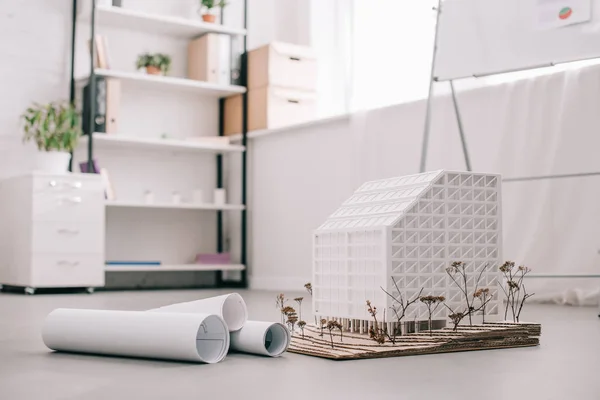 Современный архитектурный дизайн офиса с чертежами и моделью дома на переднем плане — стоковое фото