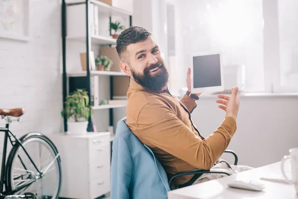 Schöner erwachsener Geschäftsmann, der am Schreibtisch sitzt und am Arbeitsplatz ein digitales Tablet benutzt — Stockfoto