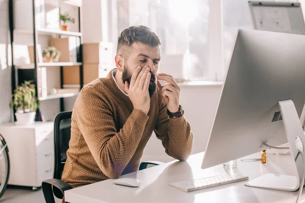 Empresário doente sentado na mesa do escritório com escorrendo usando spray nasal — Fotografia de Stock