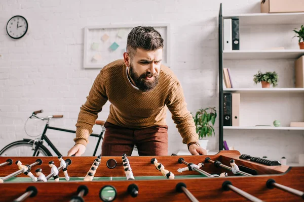 Homem adulto barbudo jogando jogo de futebol de mesa em casa — Fotografia de Stock