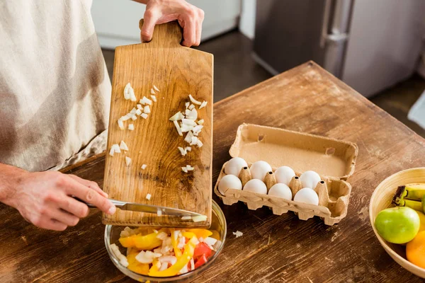 Vue partielle de l'homme dans tablier cuisine salade de légumes dans la cuisine — Photo de stock