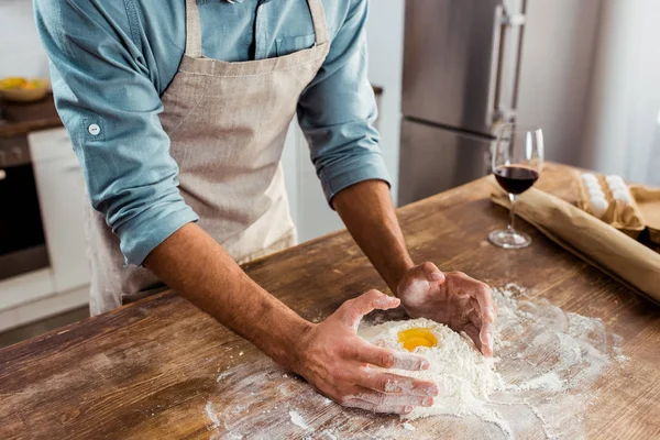 Середня секція молодого чоловіка в фартусі готує тісто на кухні — стокове фото