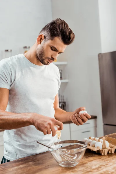 Schöner junger Mann bereitet Omelette zum Frühstück zu — Stockfoto