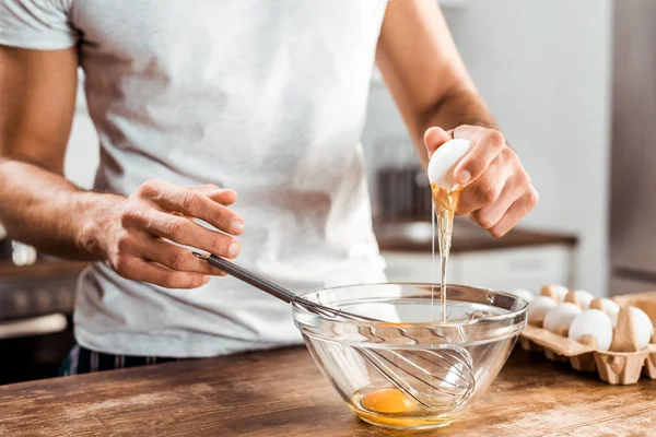 Primer plano vista parcial de hombre joven preparando tortilla para el desayuno - foto de stock