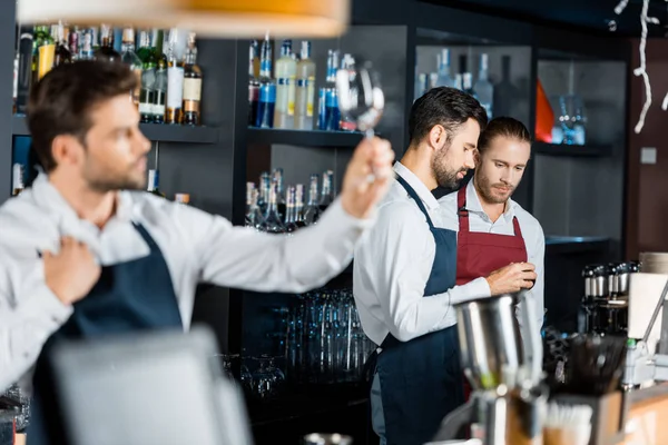 Equipe barmen em aventais de pé no local de trabalho perto de contador — Fotografia de Stock