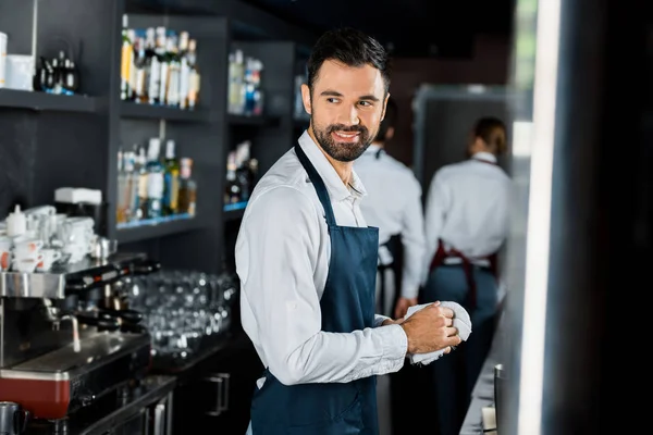 Sorridente bel barista lucidatura vetro sul posto di lavoro — Foto stock