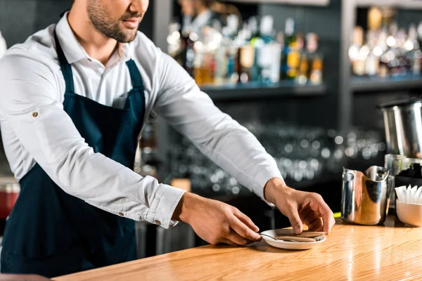 Close up of barman putting sugar sticks and spoon on saucer at counter — Stock Photo