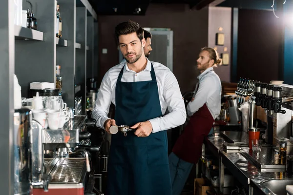 Beau barista dans tablier faire du café au travail — Photo de stock