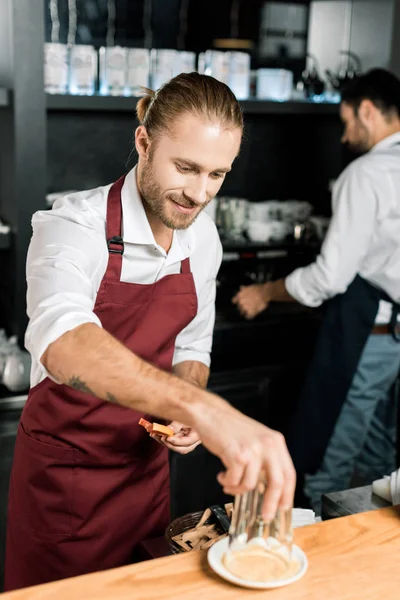 Lächelnder Barmann dekoriert Glas mit Zucker, während er Grapefruitscheiben hält — Stockfoto