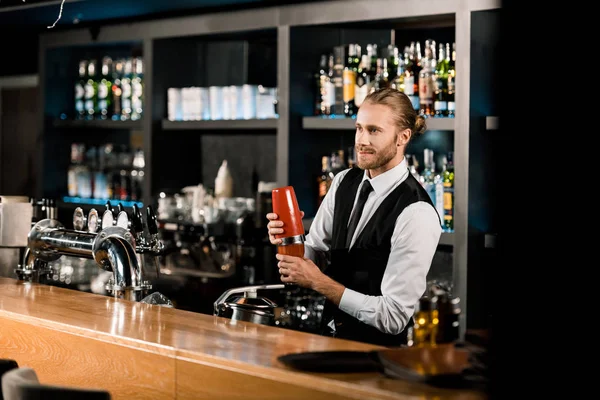 Guapo barman mezcla bebida en agitador — Stock Photo