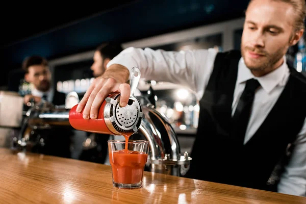Barmann gießt Getränk in Glas auf Holztheke — Stockfoto