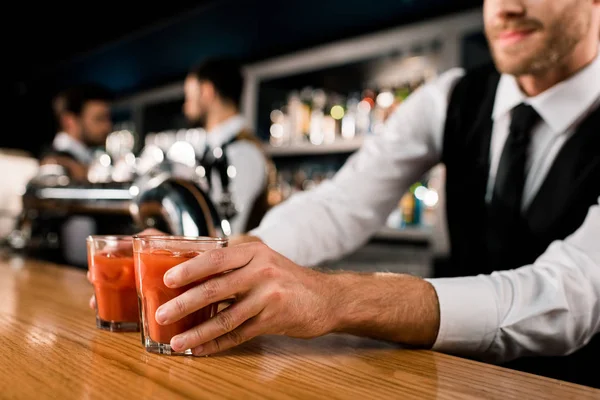 Barman servir des boissons dans des verres sur le comptoir en bois — Photo de stock
